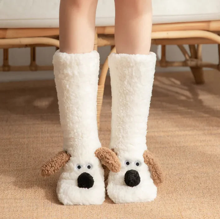 White dog-themed slippers worn by a person on a wooden floor.
